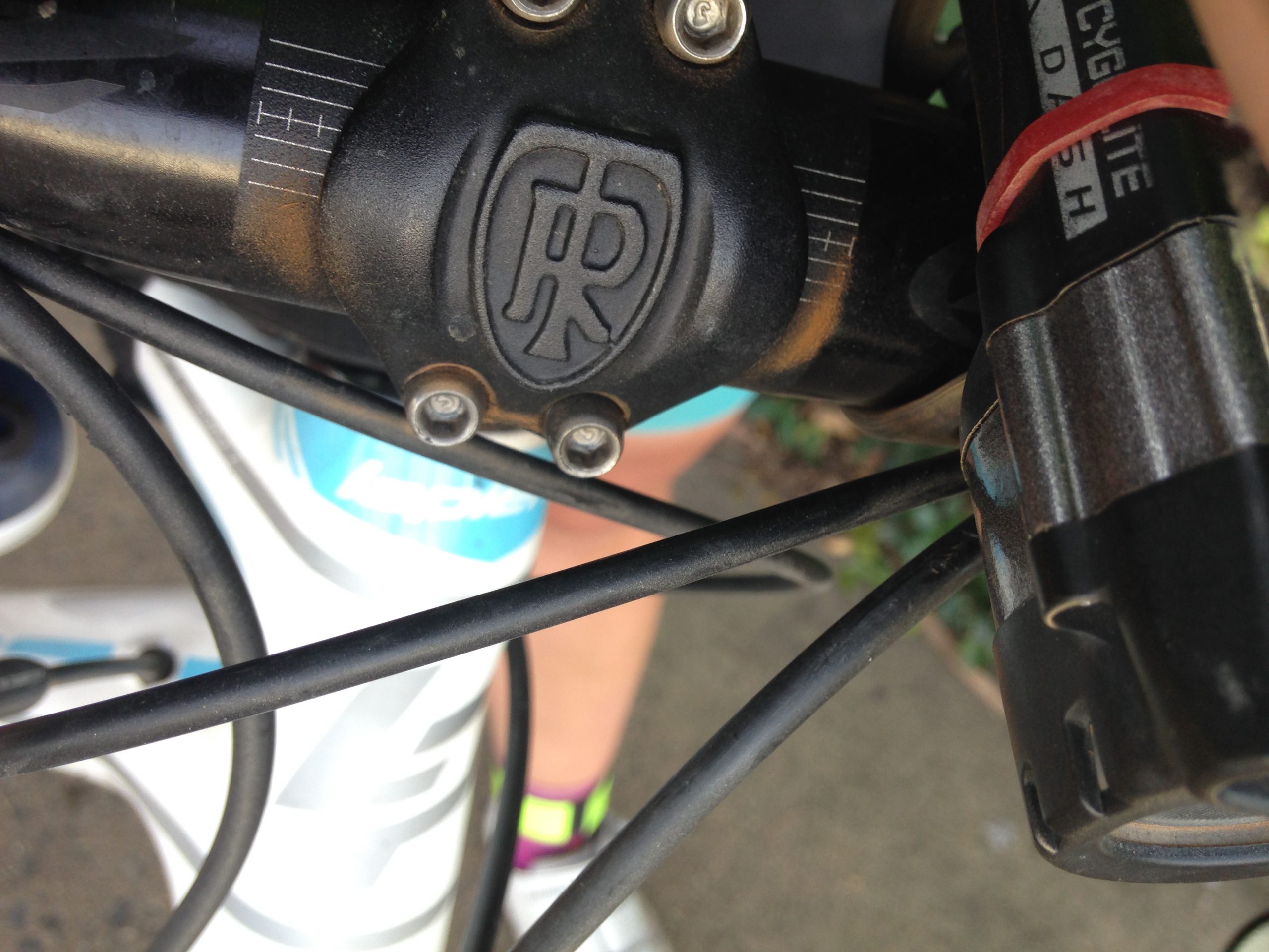 The front headset of a bicycle, with red dust visible at the crevices and bolts.